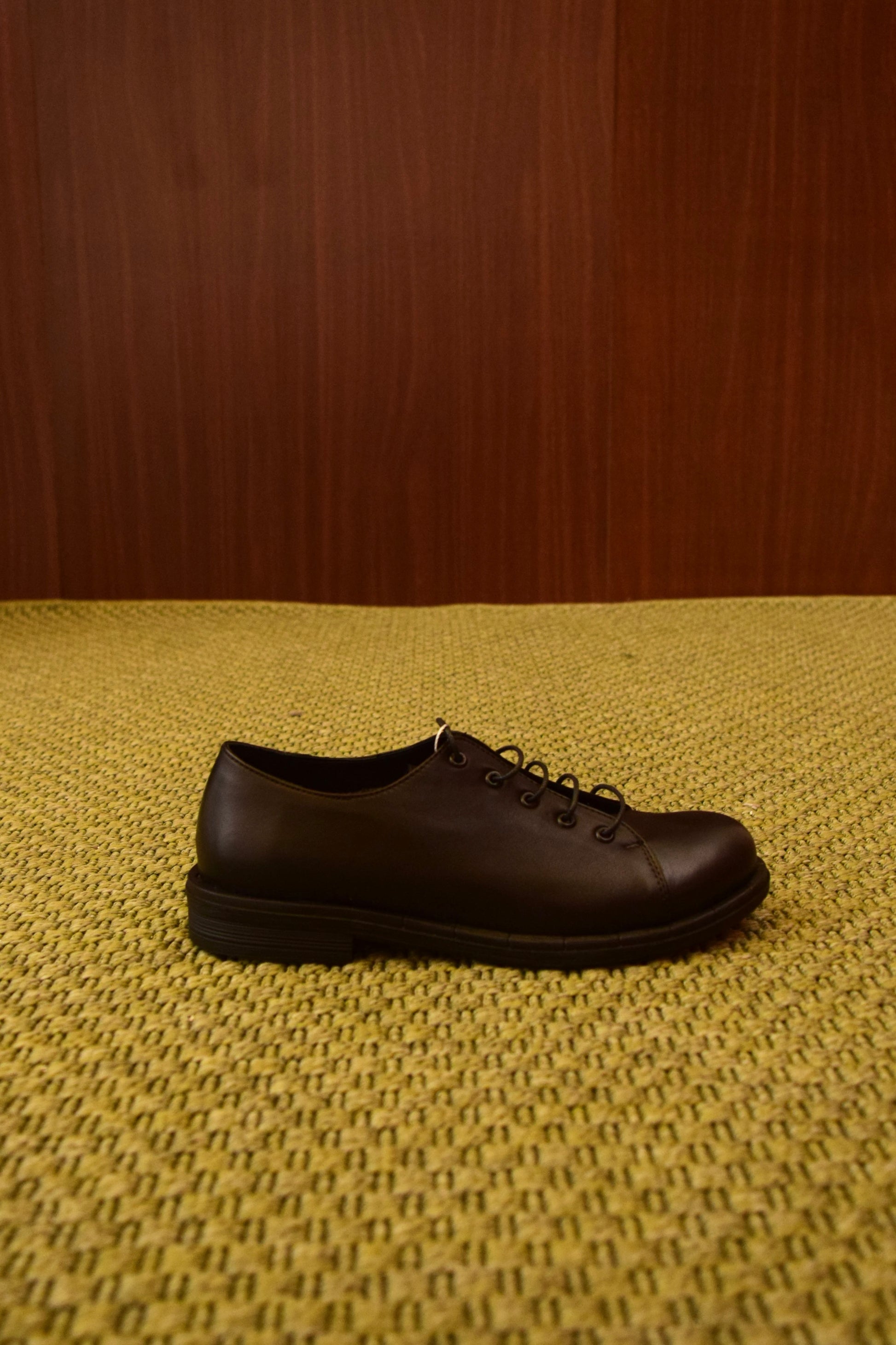 alt="Scarpa Derby stringata in pelle nera con suola coordinata"