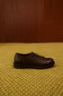 alt="Scarpa Derby stringata in pelle nera con suola coordinata"