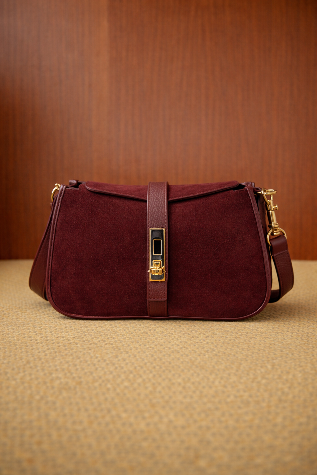 Borsa a mano donna in doppia pelle liscia e pelle scamosciata color bordeaux, caratterizzata da un elegante gioco di texture che valorizza il design essenziale. La parte in camoscio dona profondità e morbidezza visiva, mentre gli inserti in pelle liscia definiscono la struttura e i dettagli. La chiusura frontale con elemento metallico aggiunge un accento raffinato, mantenendo uno stile pulito e contemporaneo. Compatta ma funzionale, è una borsa versatile, ideale per accompagnare look quotidiani e serali con