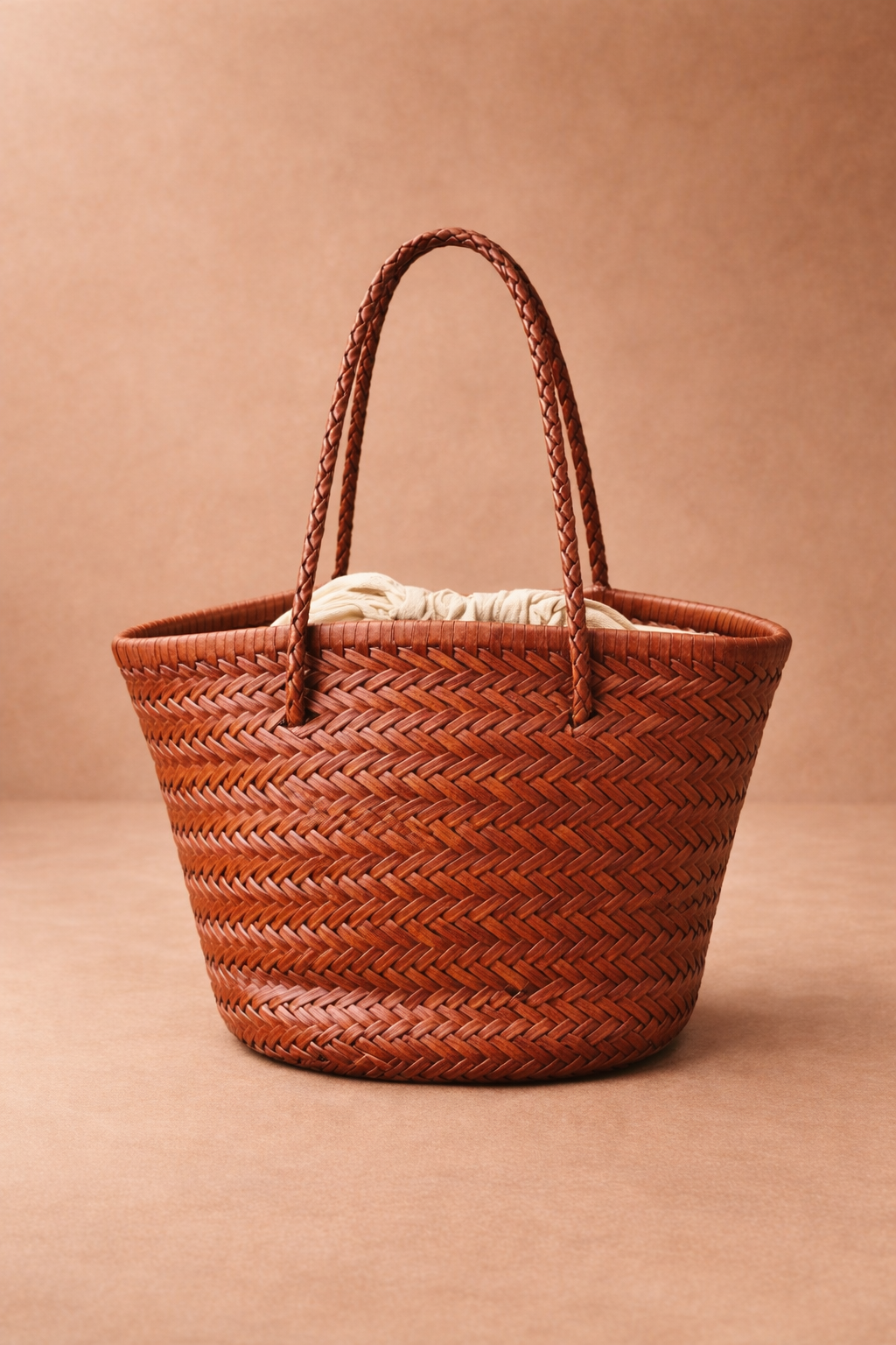 Una borsa che racconta il valore del tempo e della manualità. Realizzata in vera pelle e intrecciata a mano, ogni pezzo nasce da un lavoro artigianale paziente, dove ogni fascia di pelle viene lavorata singolarmente per creare una trama unica e autentica.
Il colore cuoio ne esalta il carattere naturale e senza tempo, rendendola un accessorio versatile, capace di accompagnare ogni look con eleganza spontanea.
All’interno, una sacca in cotone con chiusura a coulisse custodisce gli oggetti con praticità, mante